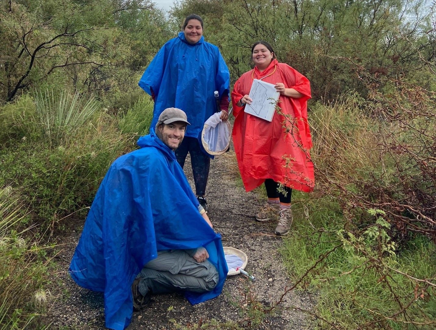 students in ponchos on a research hike