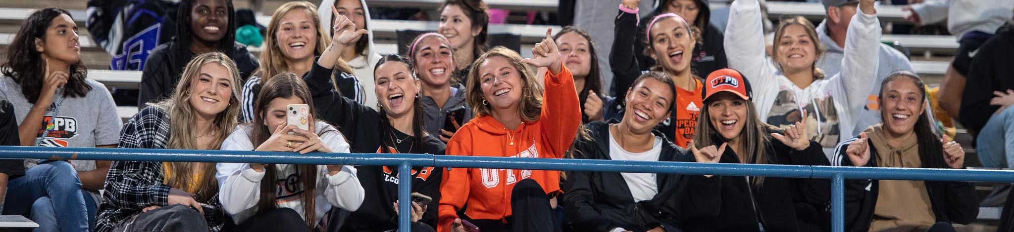 Students smiling together at football game