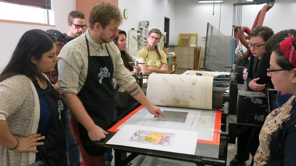 Students printing the editions in the printshop