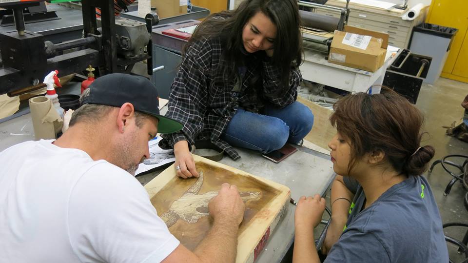 Estudiantes de arte que trabajan con O'Malley en una piedra litográfica
