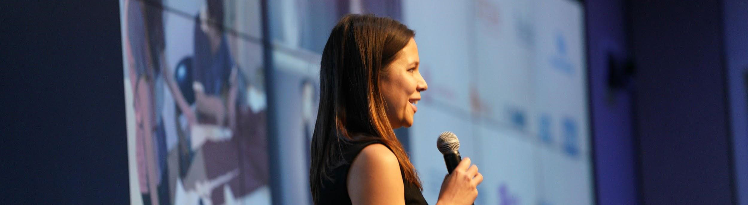 Lady talking on stage at a conference