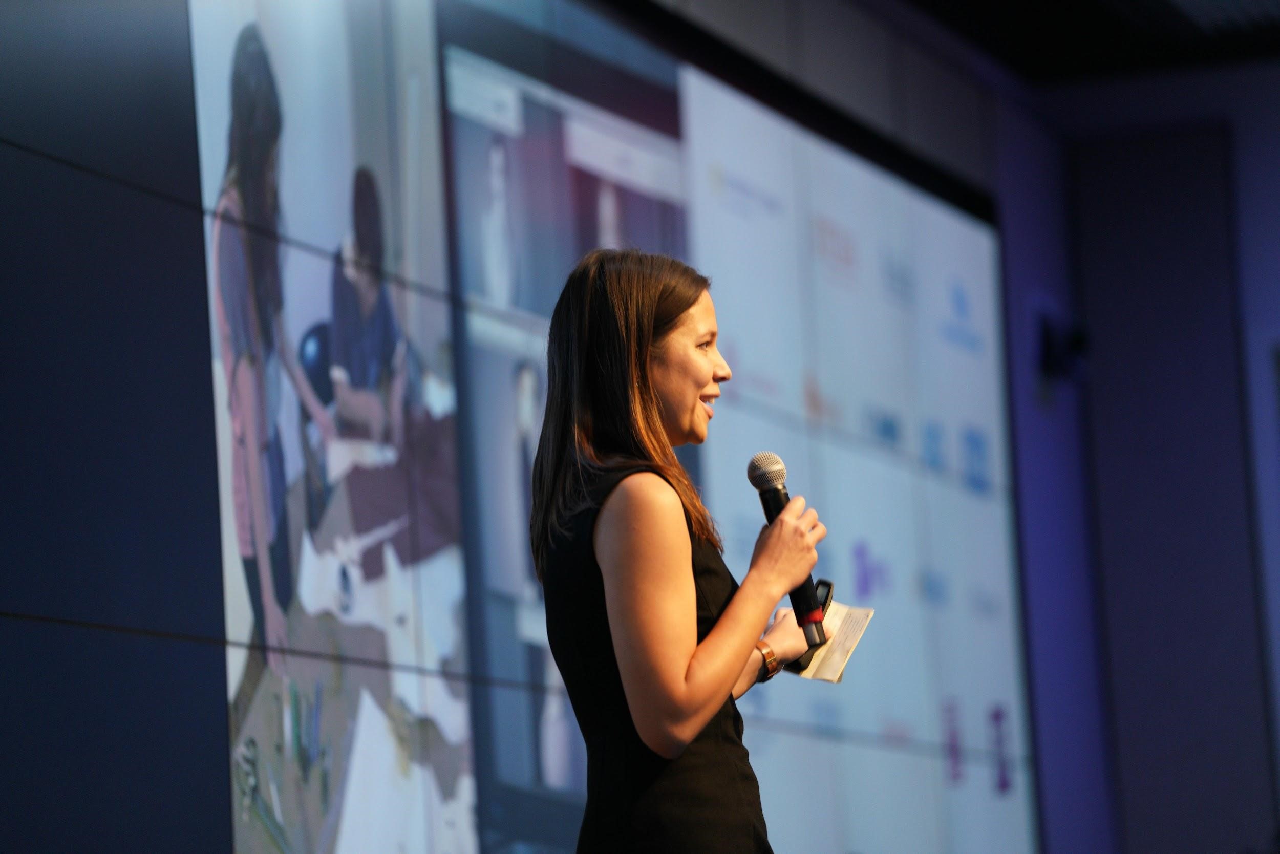 Lady talking on stage at a conference