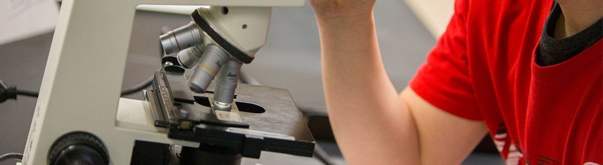 student looking through microscope