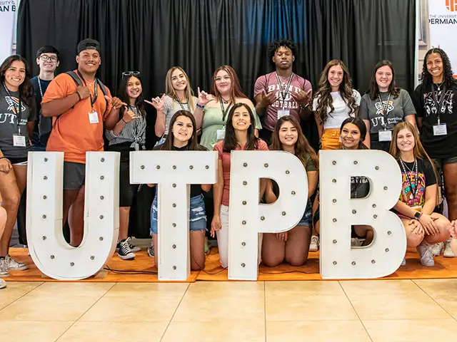Grupo de estudiantes detrás de letras grandes UTPB