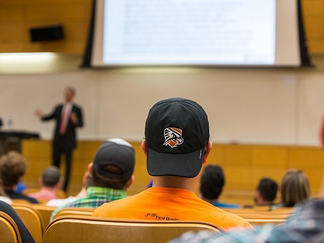 Chico en una sala de conferencias con sombrero Falcon Shield