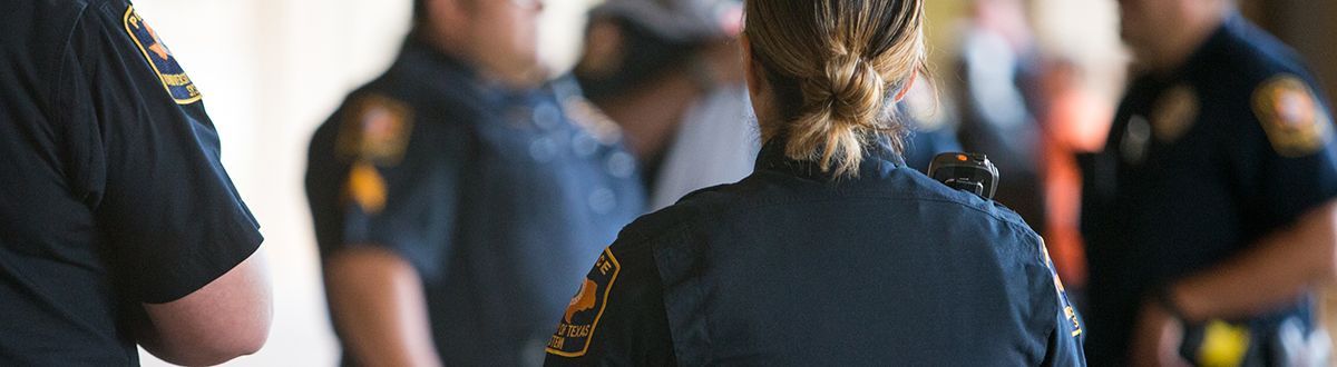 Officers in a big room at a career day talking to students