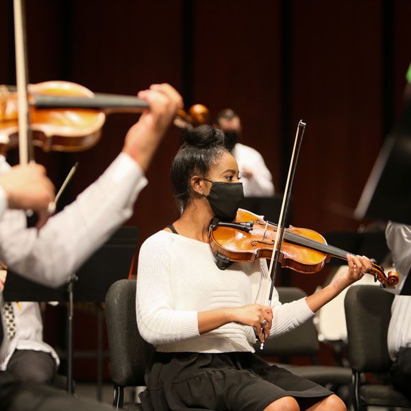 Chica tocando el violín en el escenario