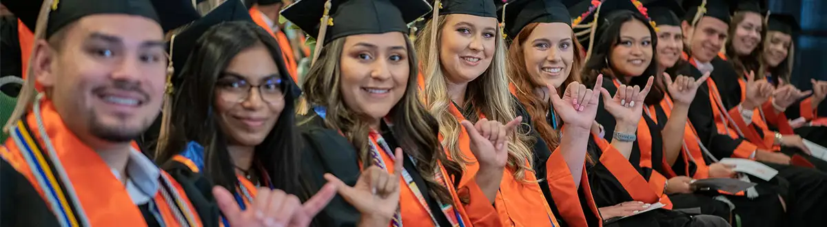 graduates showing falcon up hand sign