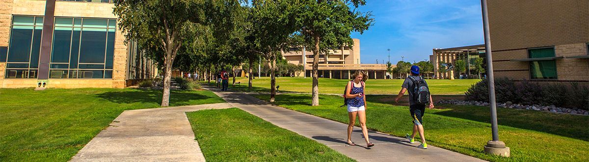 Estudiantes caminando afuera en el campus