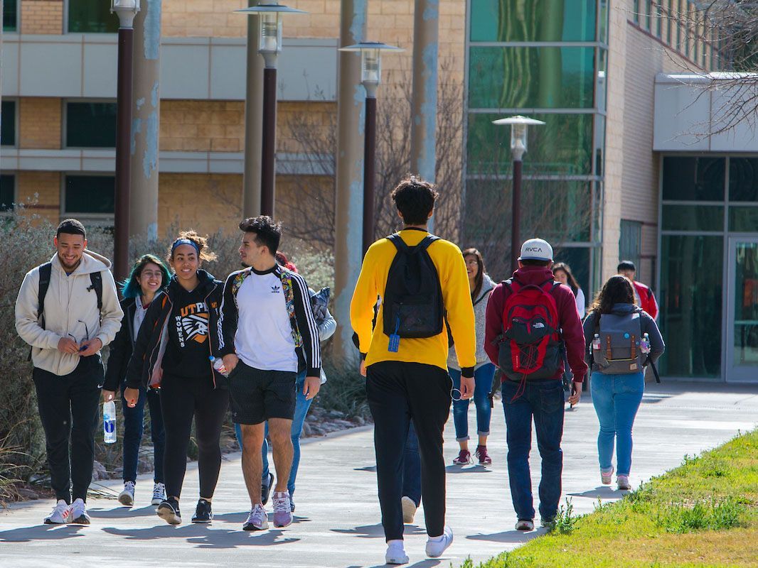 Estudiantes caminando de ida y vuelta a clases en el campus.