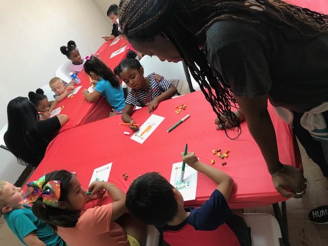 Kindergarten students coloring around table