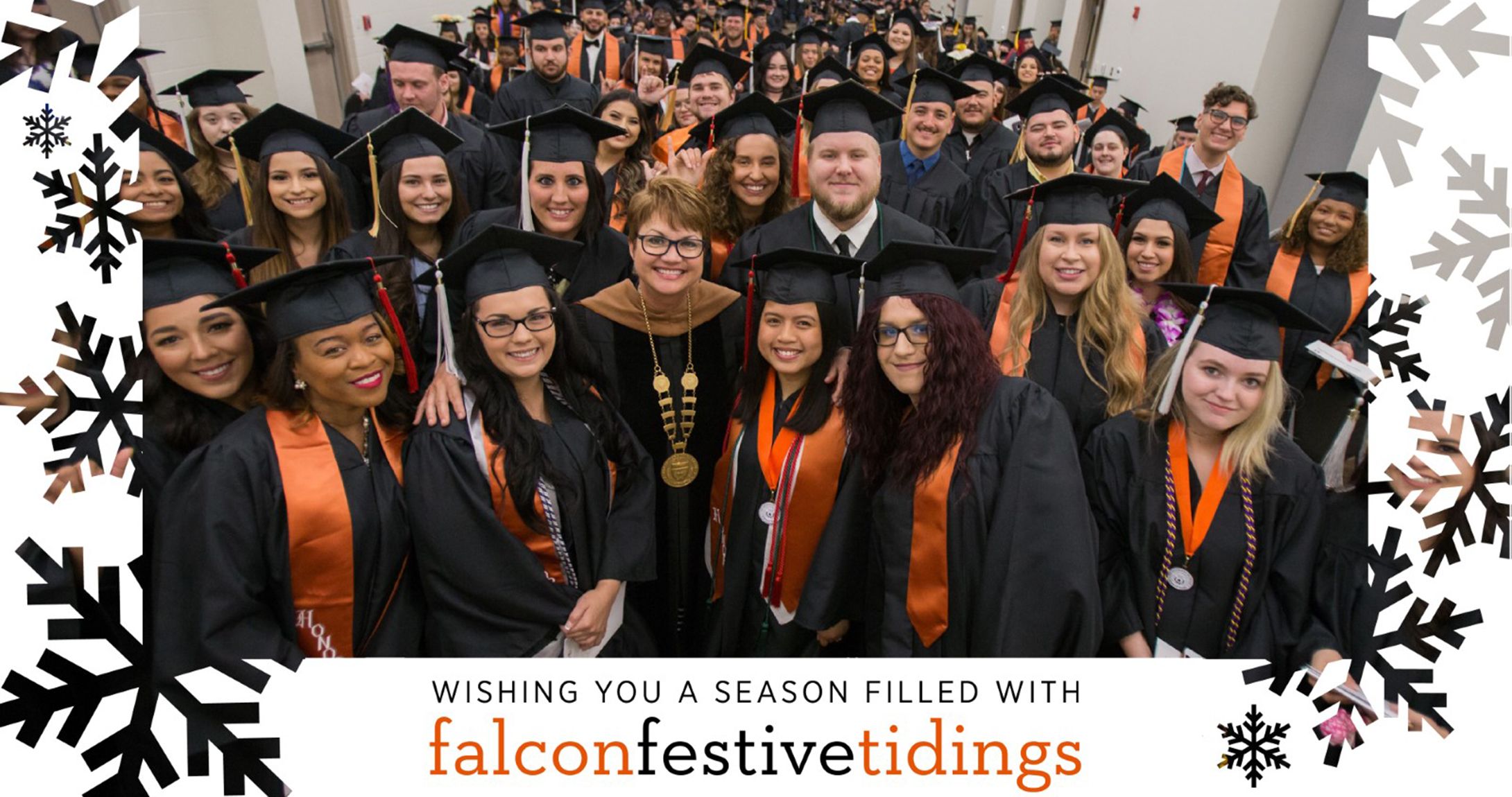 Dr. Woodley smiles with students at graduation