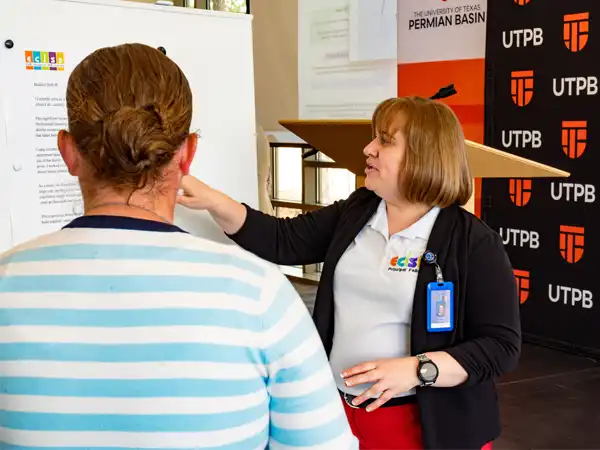 UTPB staff member speaks with prospective students during an on-campus event or informational session.