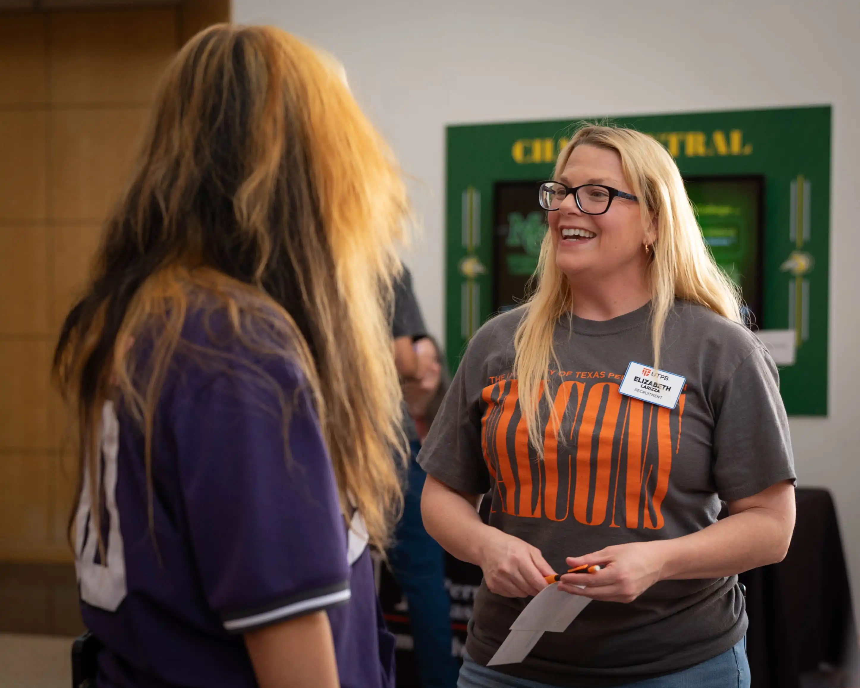 A UTPB staff member talking with an Odessa College student at a transfer fair. 