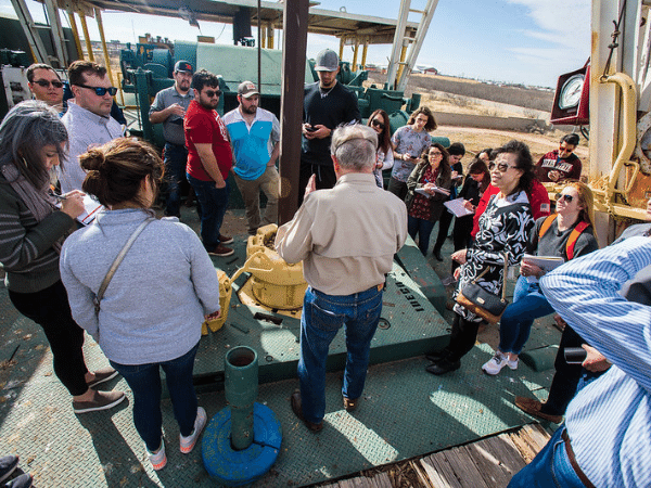 Students standing around oil rig learning 