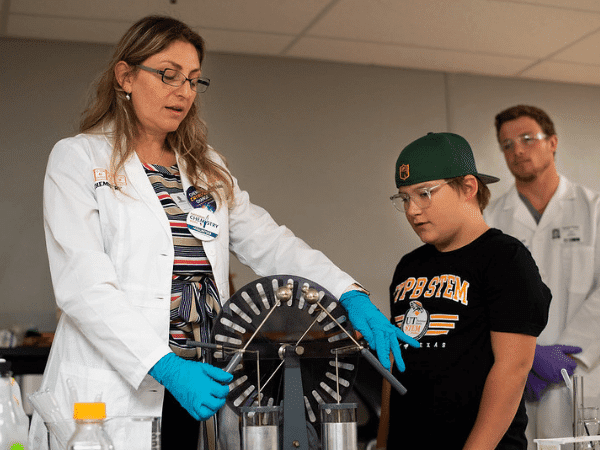 Profesor de ciencias que muestra el experimento del estudiante