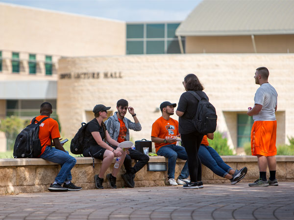 Estudiantes sentados afuera almorzando juntos