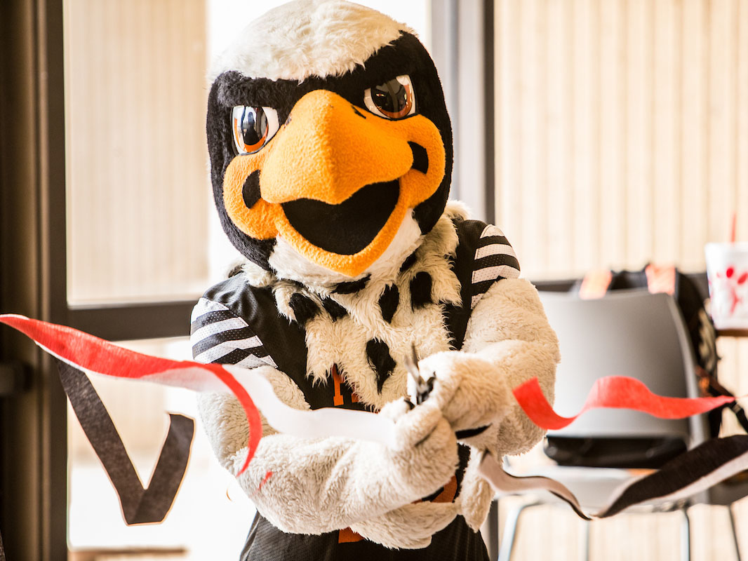 Freddy Falcon cutting a ribbon 