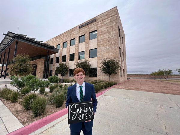 Jayden Gray with Senior 2023 sign in front of the Engineering Building