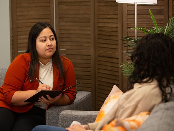 UTPB Student holding pen and paper while counseling another student