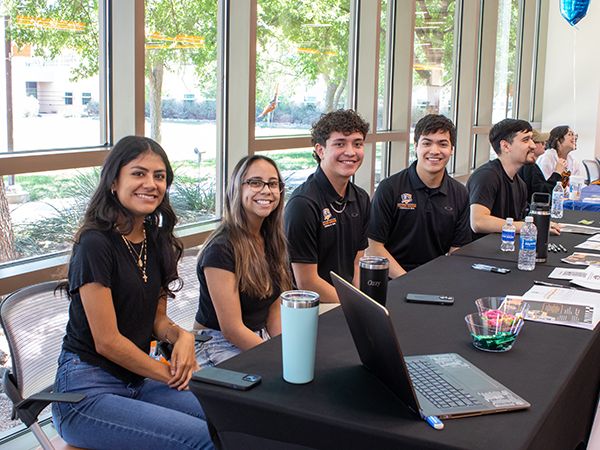 UTPB students sitting at a table at Falcon Day