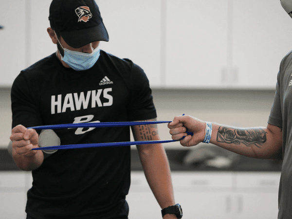 Student using workout band in athletic training room