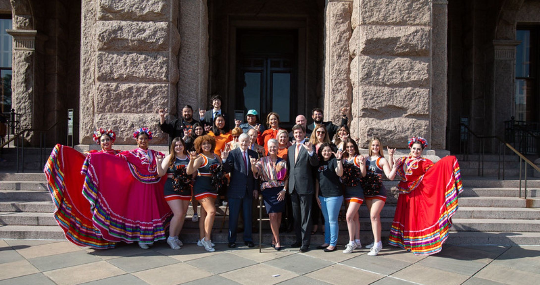 Students and staff smiling on Texas State Capitol steps 