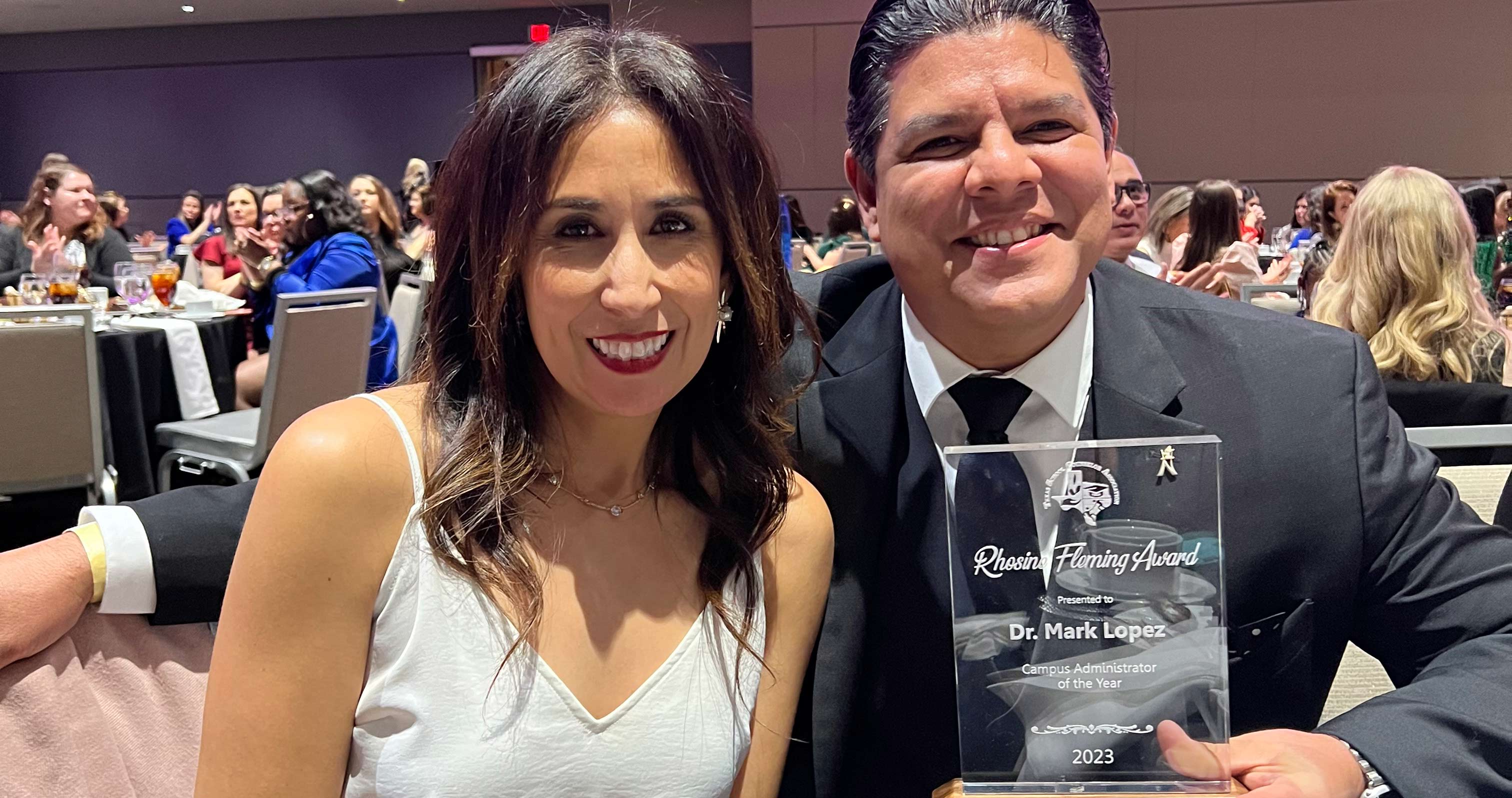 UTPB alum pictured holding award with wife