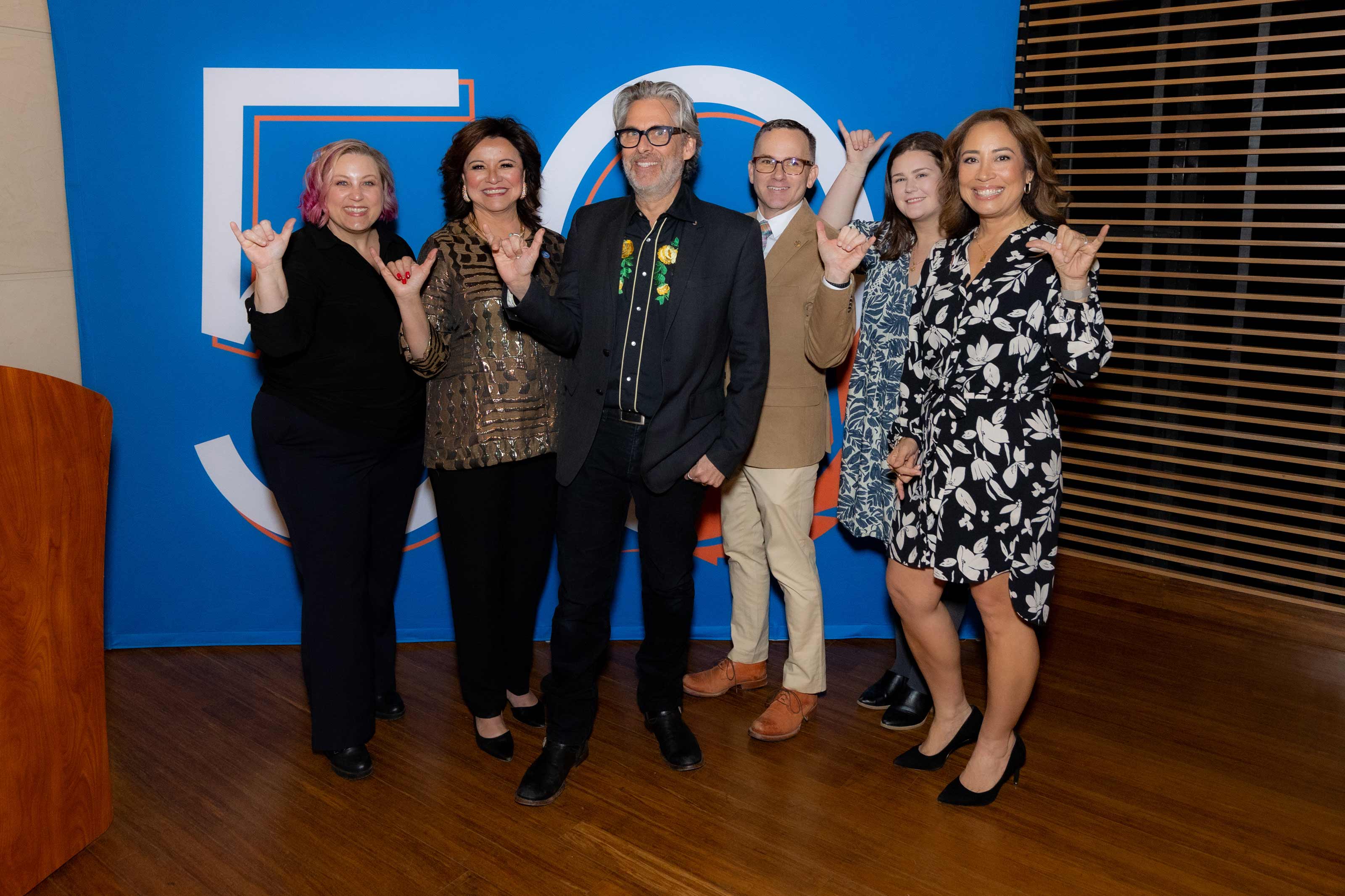 Michael Chabon posando con la mano "Falcons Up" junto a otros empleados de la UTPB