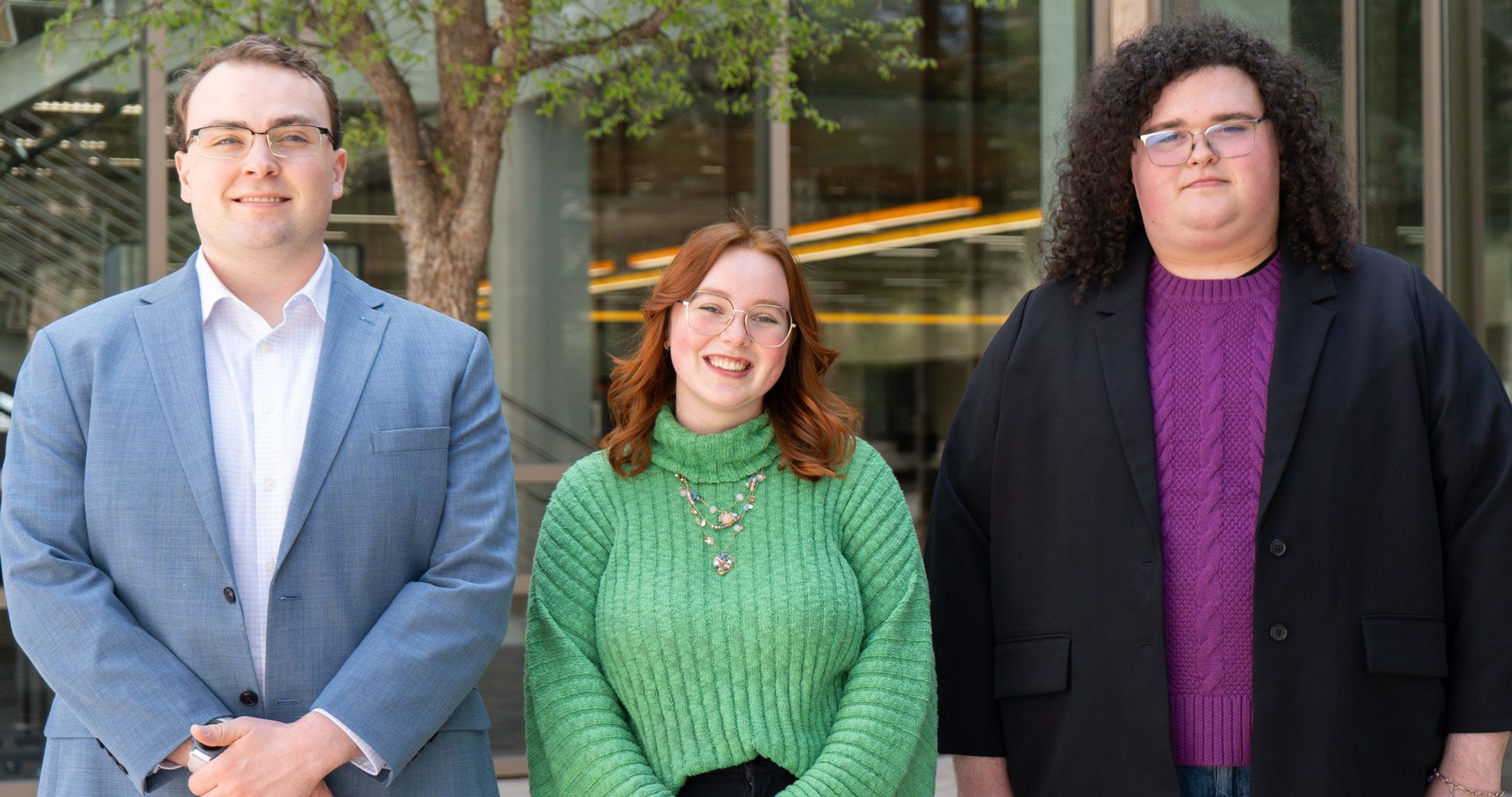 Three students attending the conference smiling 