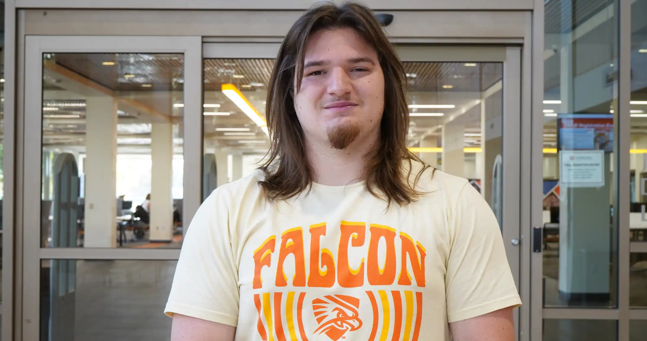 Dallas McWilliams, SGA President, standing in the on-campus library. 