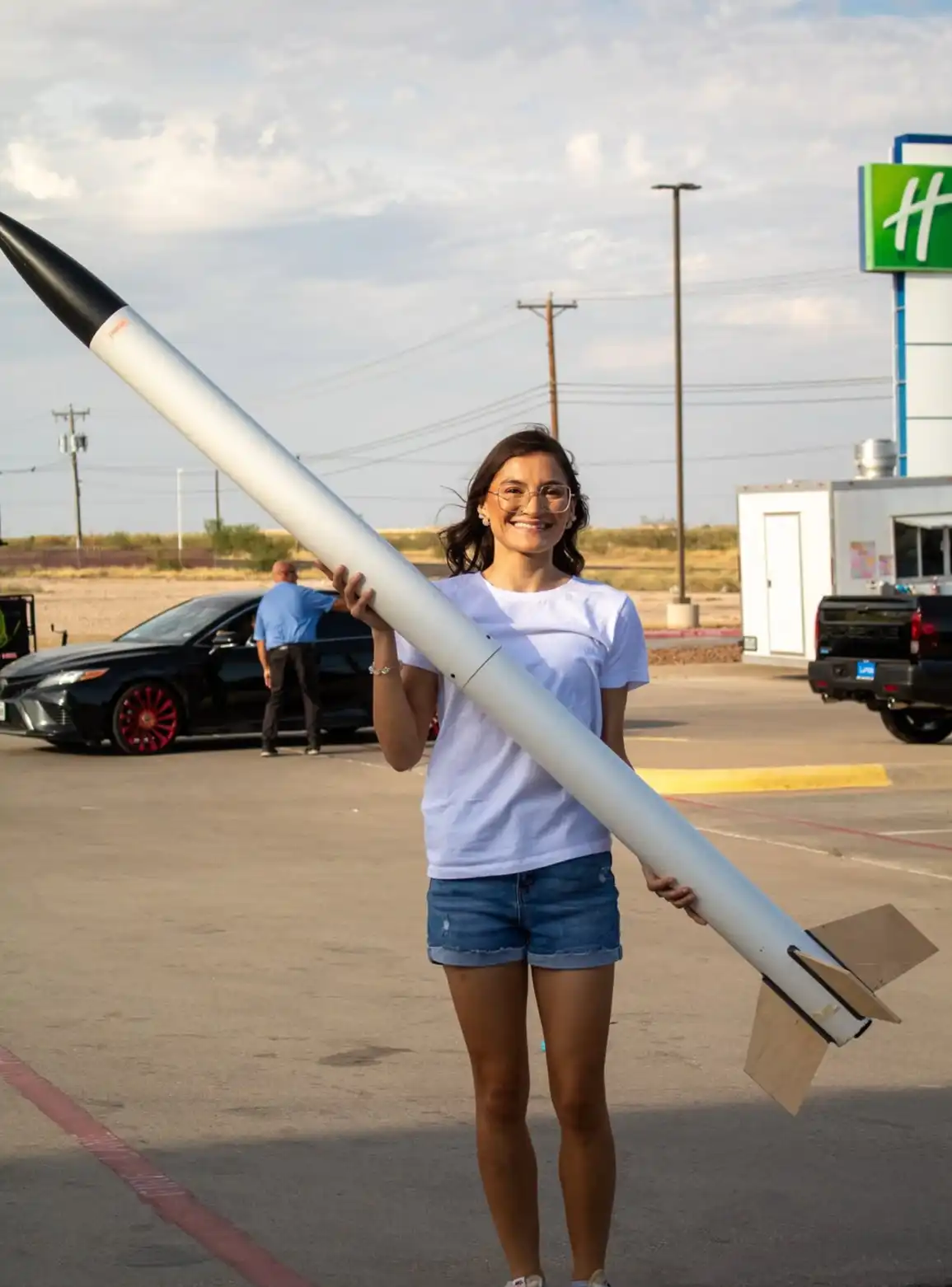 Raquelle Bernal, FAST team president, standing with a rocket she built. 