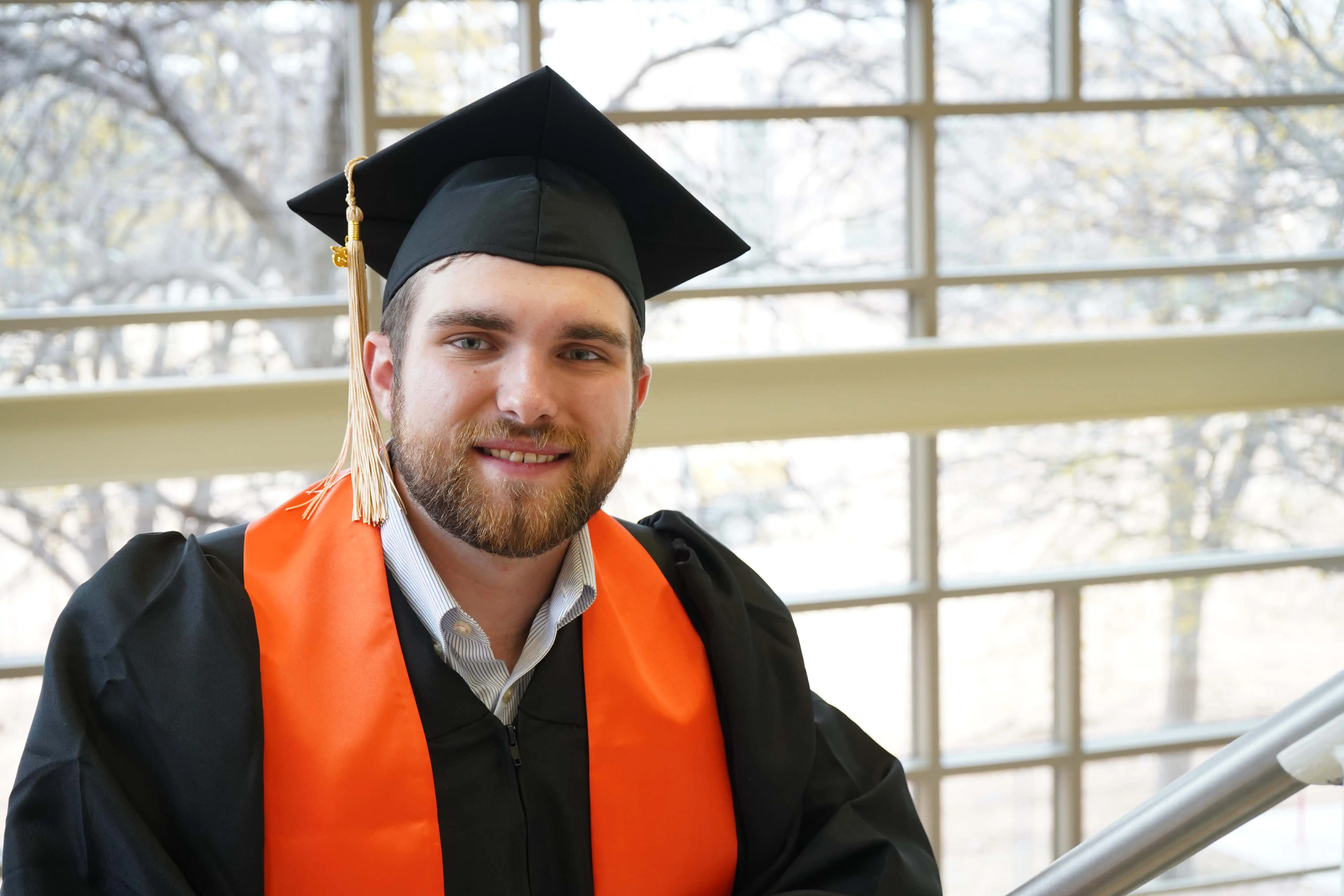 Noah Powell, UTPB graduate, standing in the on-campus library. 