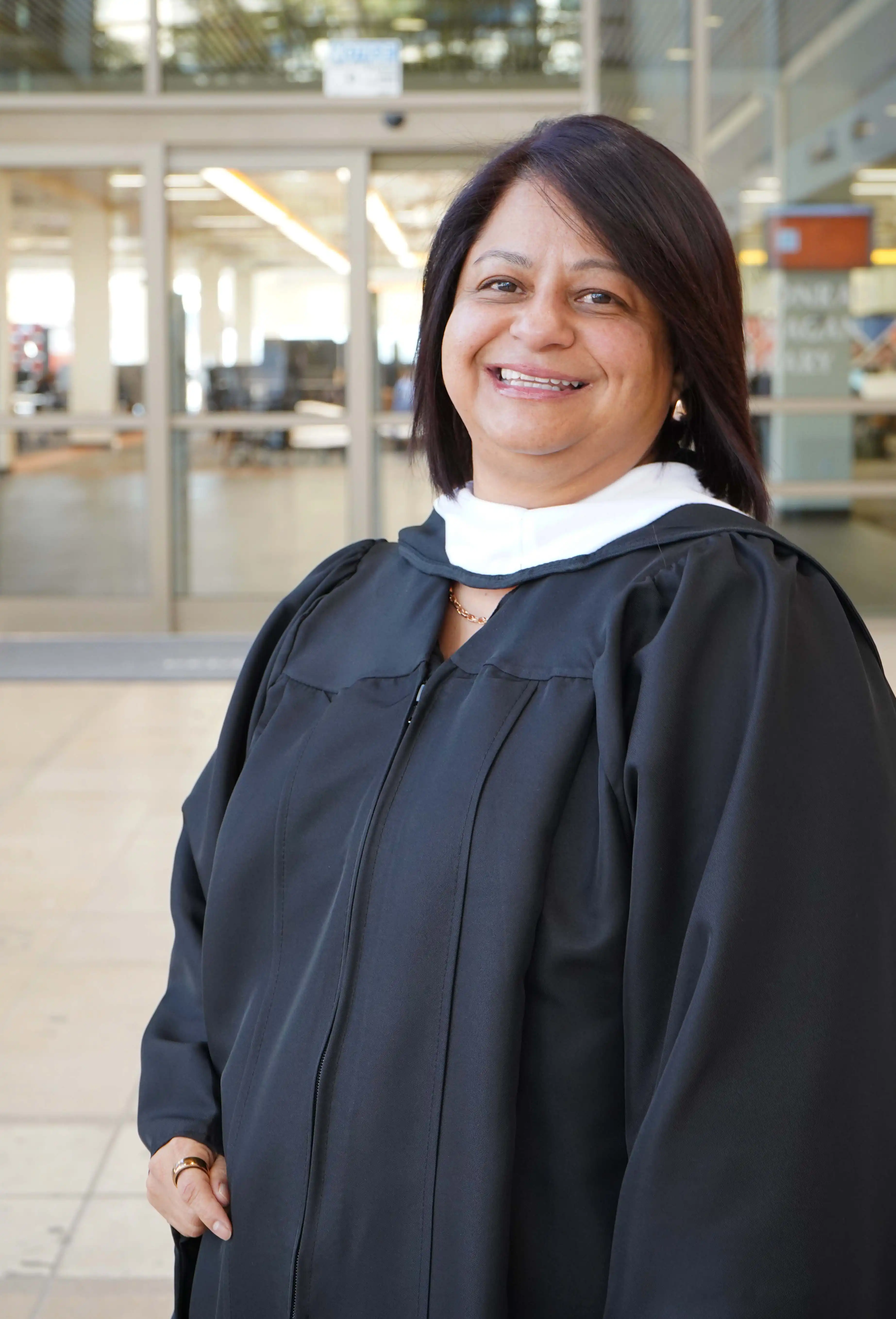 UTPB graduate, Priscilla Martinez, standing in the on-campus library foyer. 