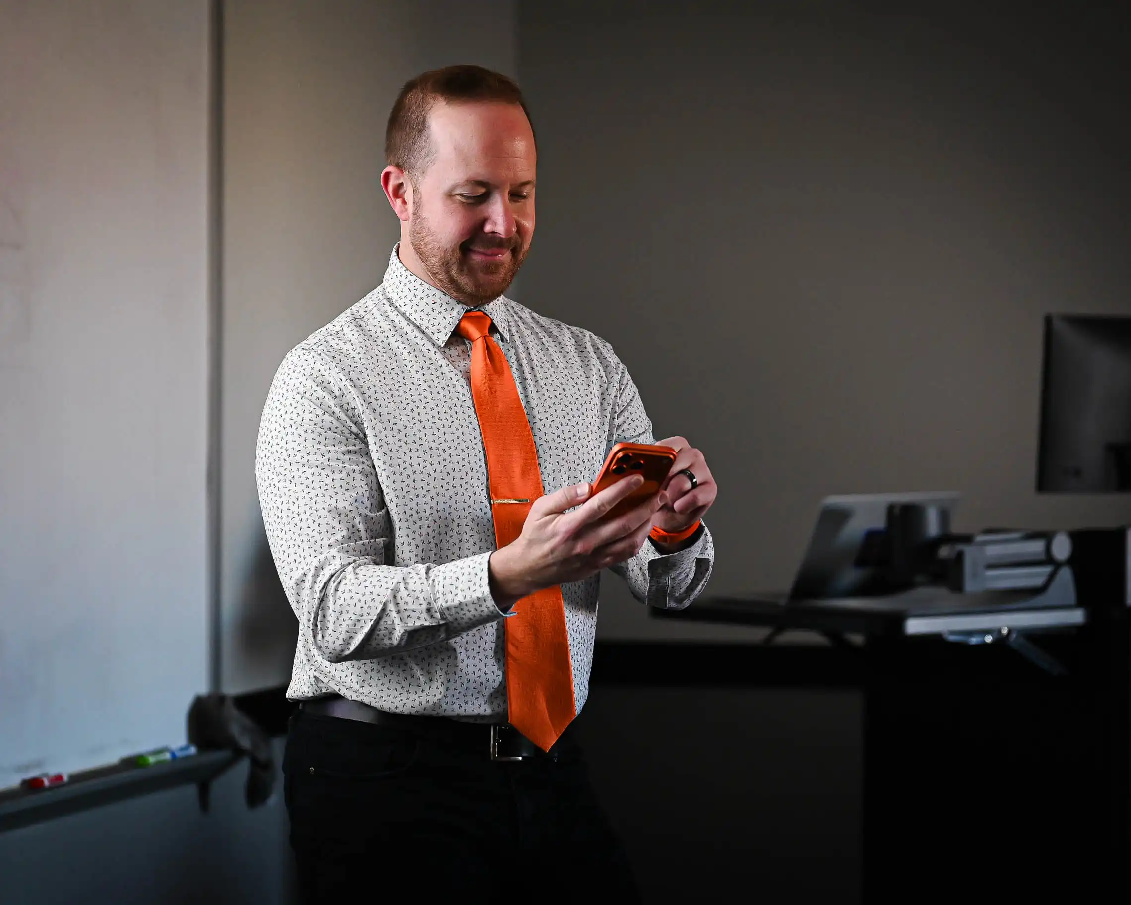 Eric Baker using his phone to pull up the AI Teaching Assistant. 