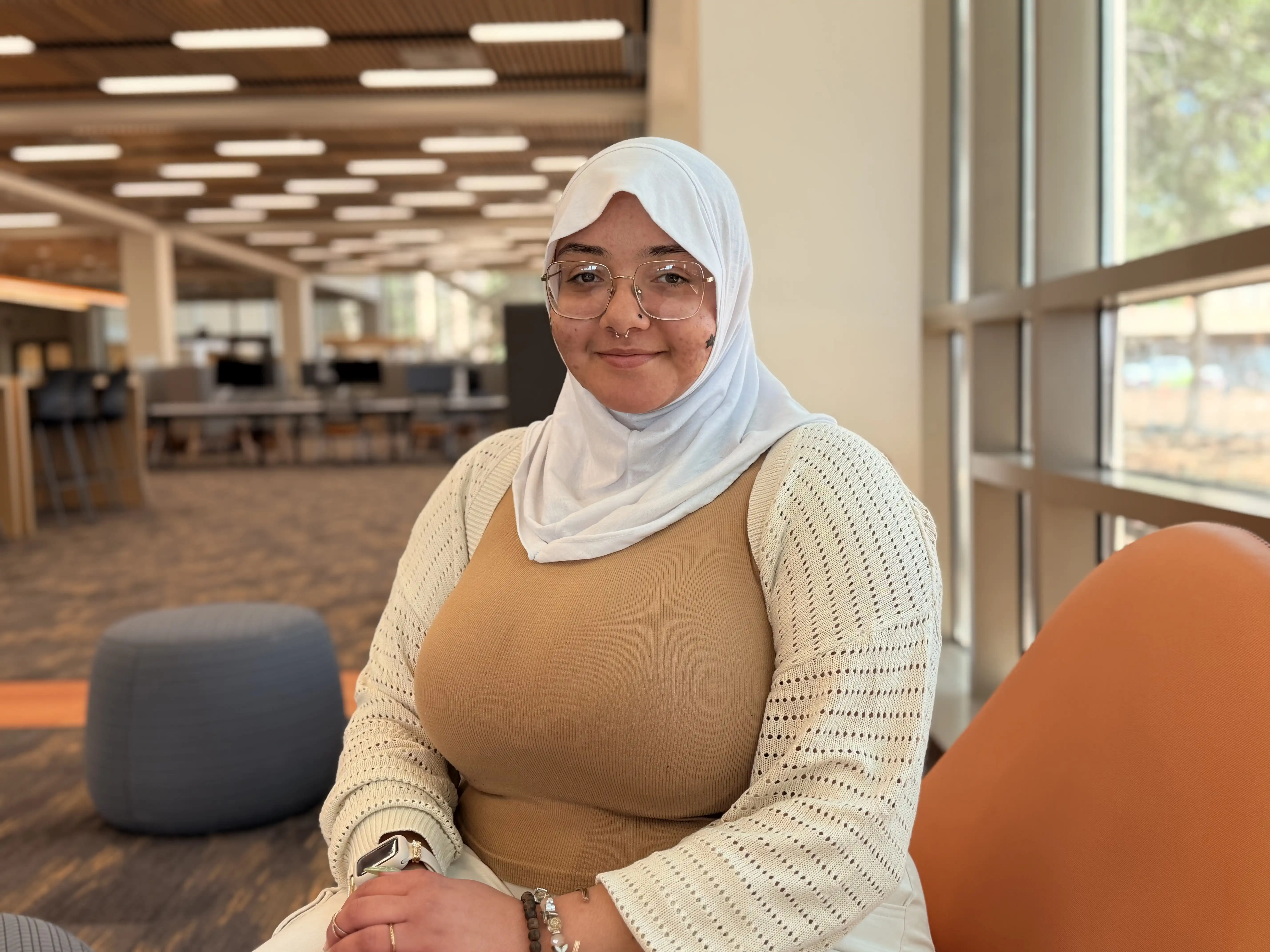 Areej Khodair sitting in the UTPB library. 
