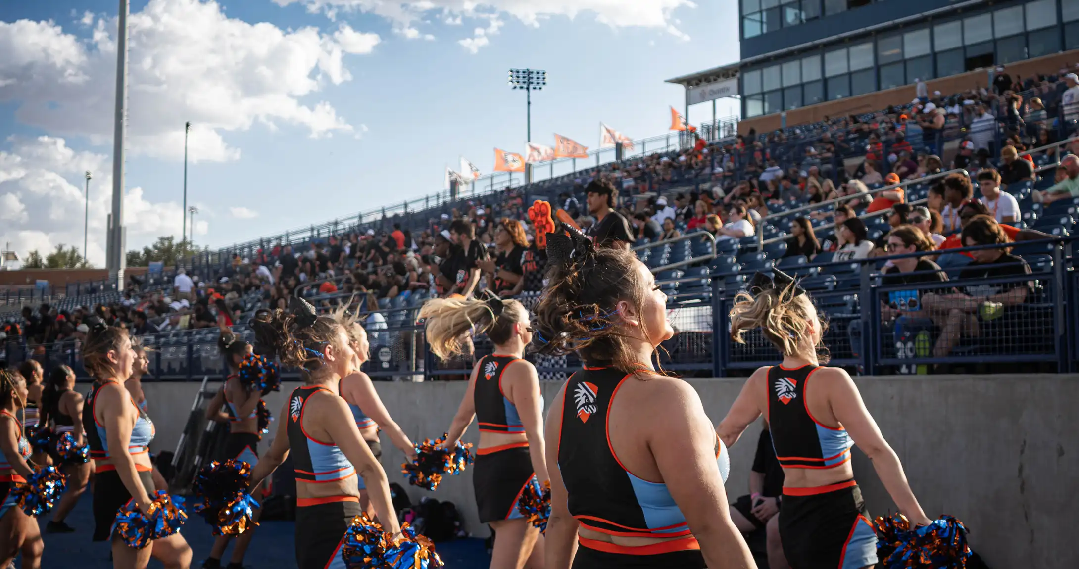 The UTPB cheer team cheering to the crowd at a football game. 