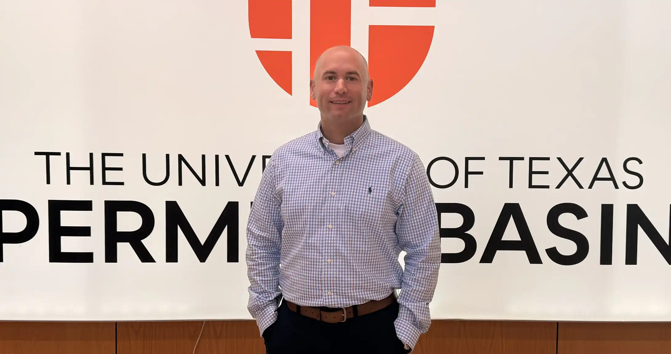 UTPB student Quintin Malo standing in front of the UTPB logo on campus. 