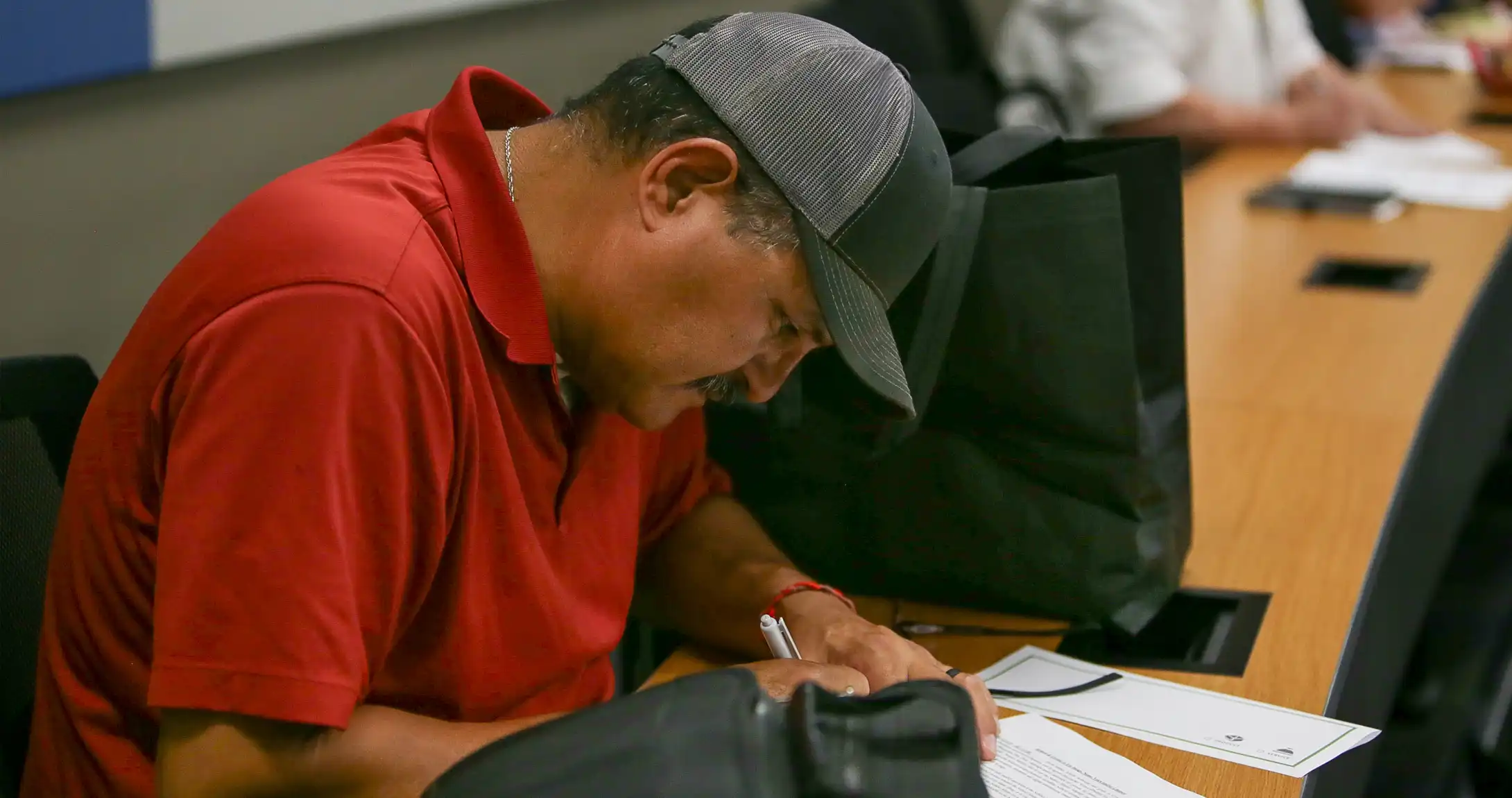 A man at the SmallBiz Builder class taking notes at a desk.