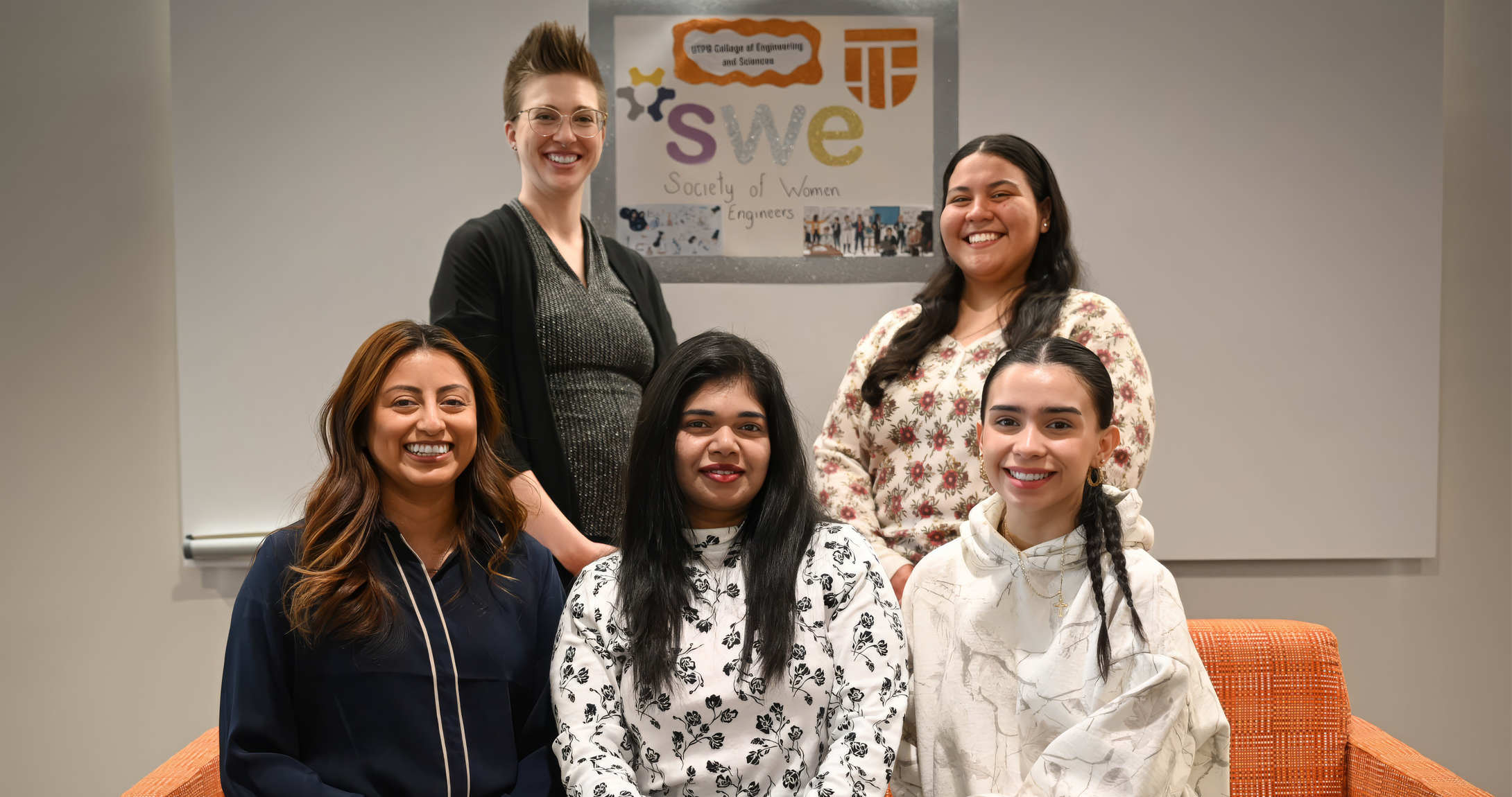 A group of four of UTPB's Society for Women Engineers club members and their faculty advisor posing for a group photo.