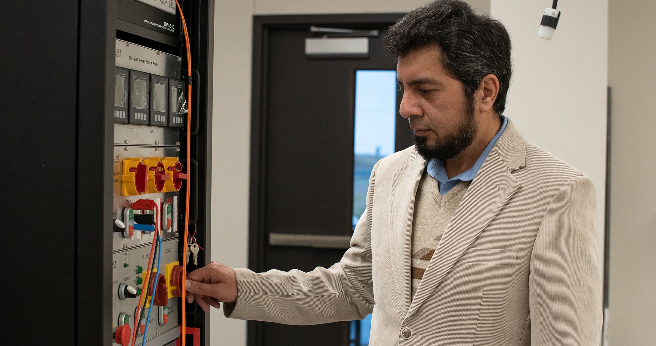 Dr. Omar Beg working with equipment in electrical engineering lab