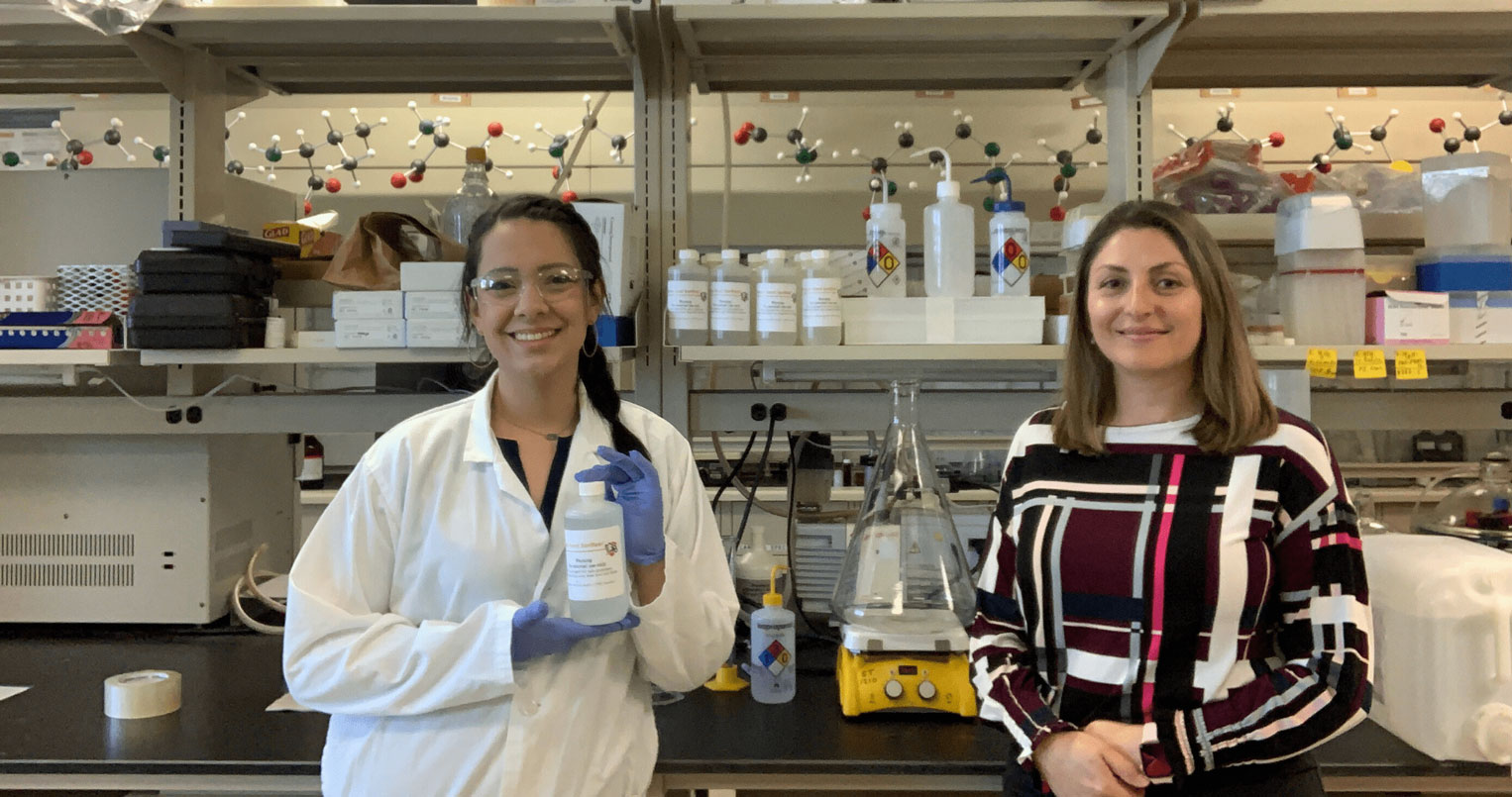 Profesor de química y estudiante sostienen desinfectante de manos de halcón