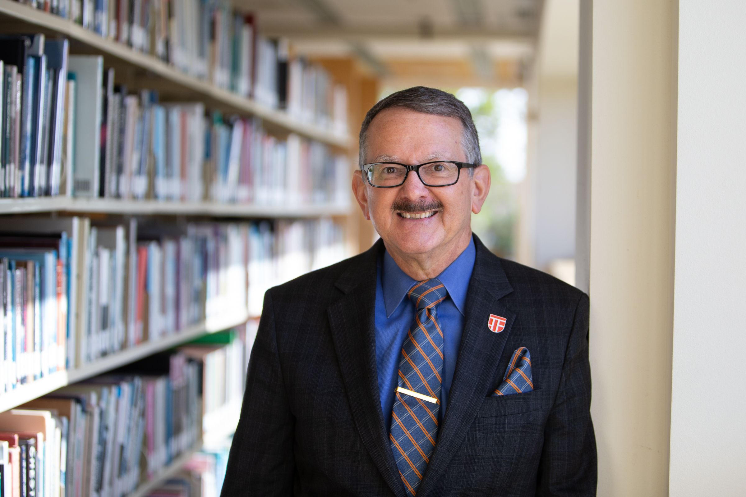 Dr. Daniel, College of Education Dean posing at library