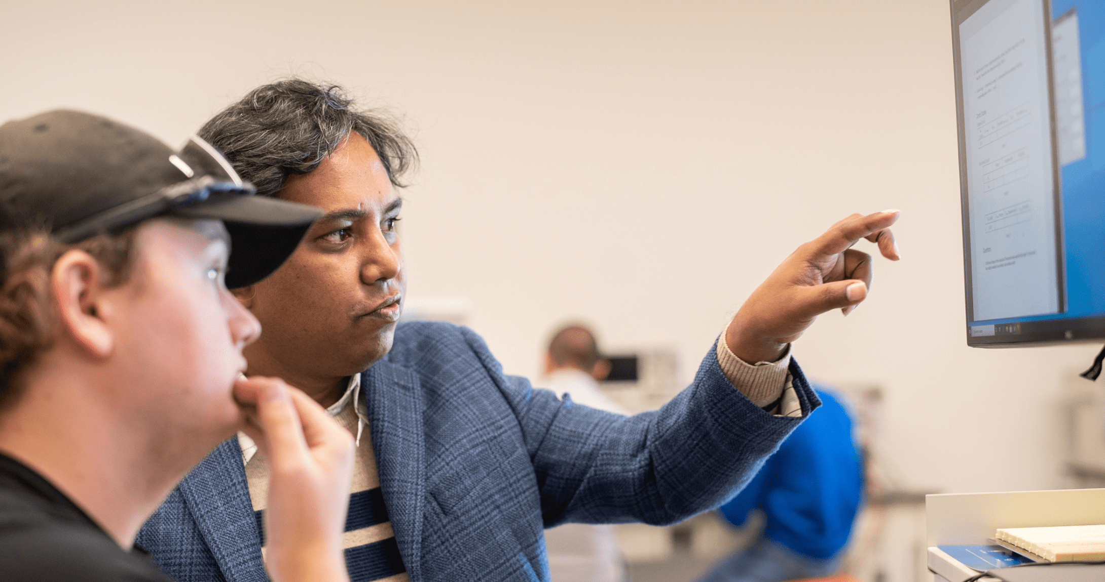 Engineering student and professor working on lab computer