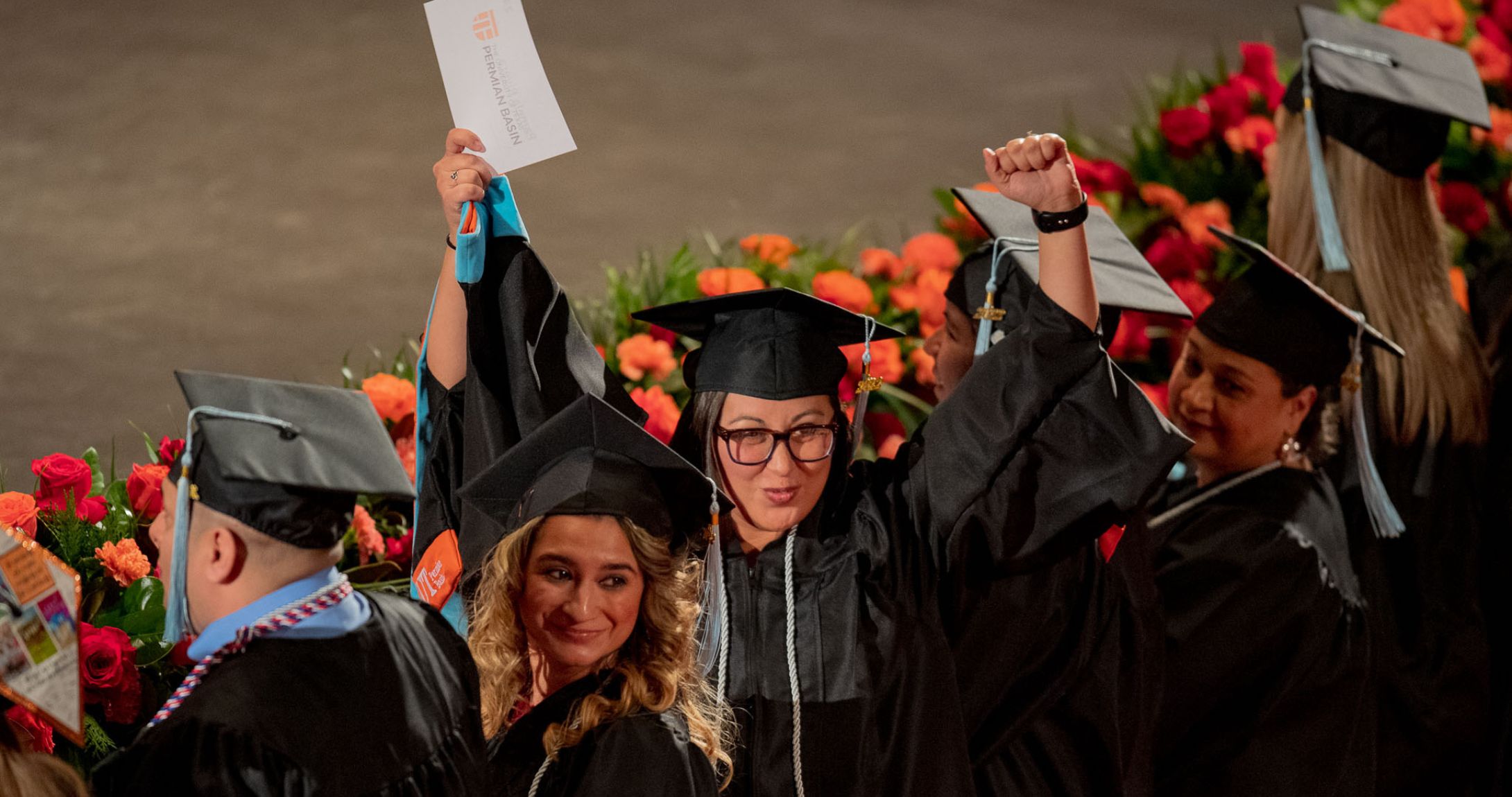 estudiante graduado levantando la mano