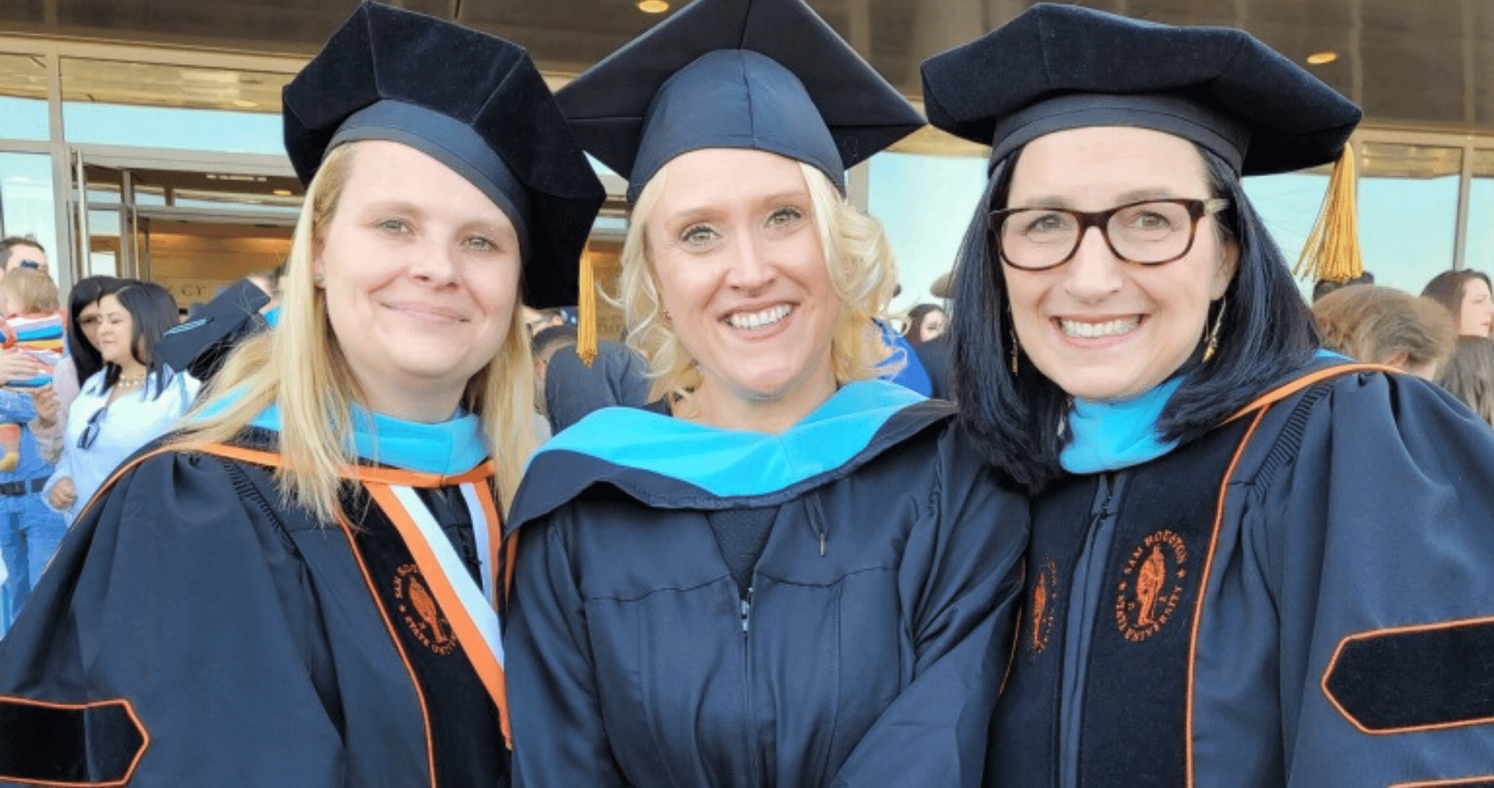Professors with graduate with cap and gown