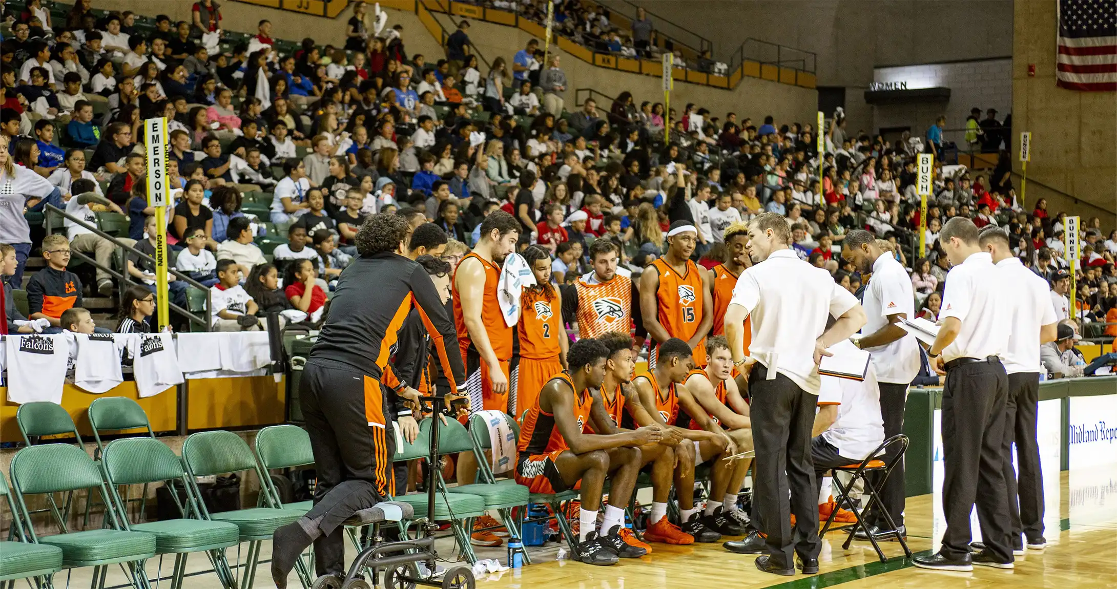 Men's basketball team huddled around coaches during game
