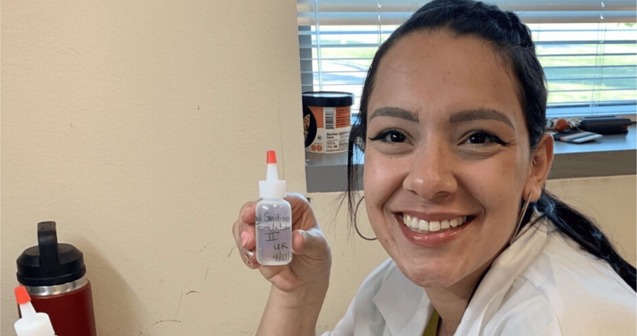 Student researcher, Mikayla Rodriguez holding hand sanitizer 