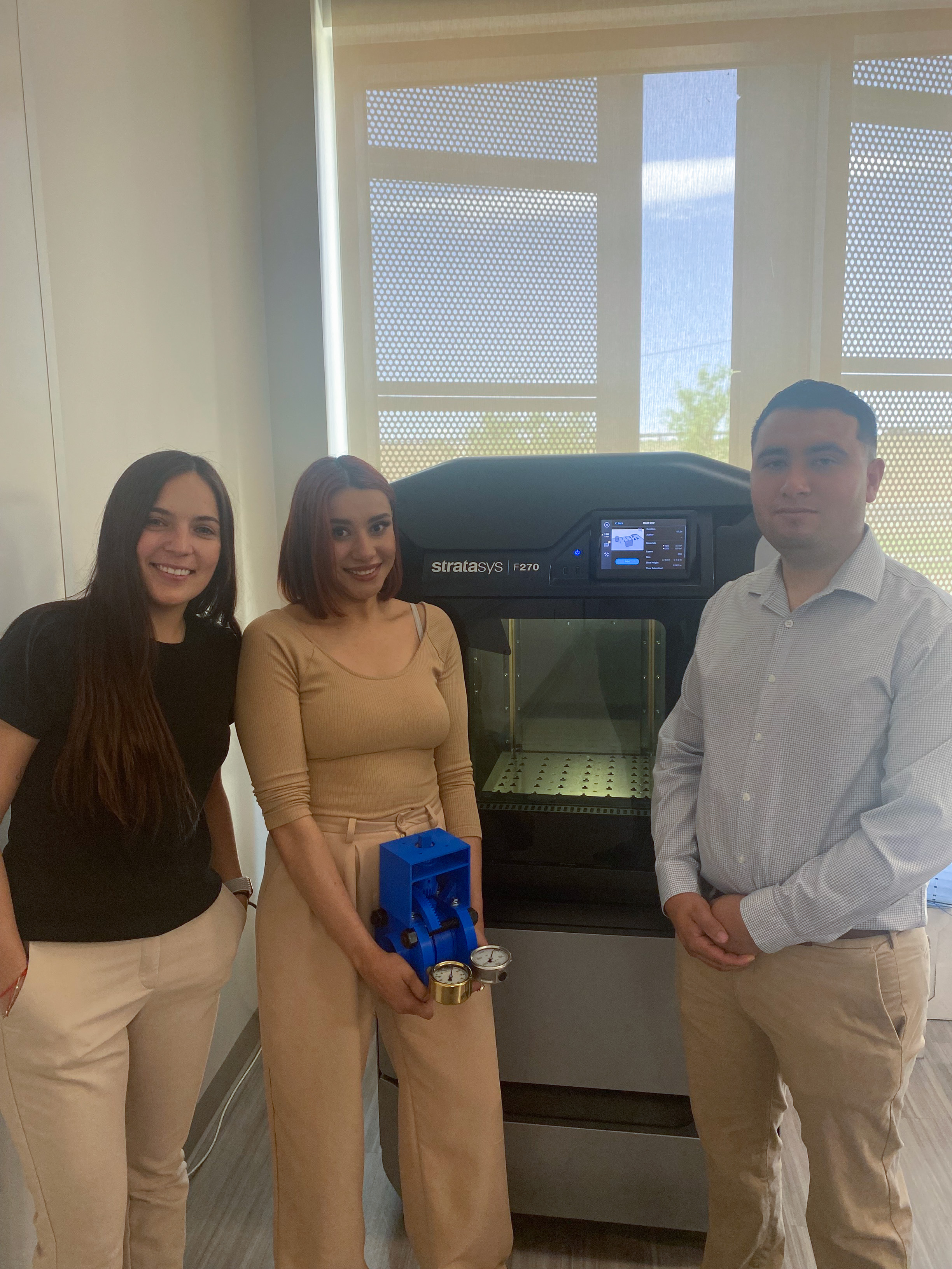 Estudiantes de ingeniería mecánica Marian, Maribel y Esteban con impresora 3D