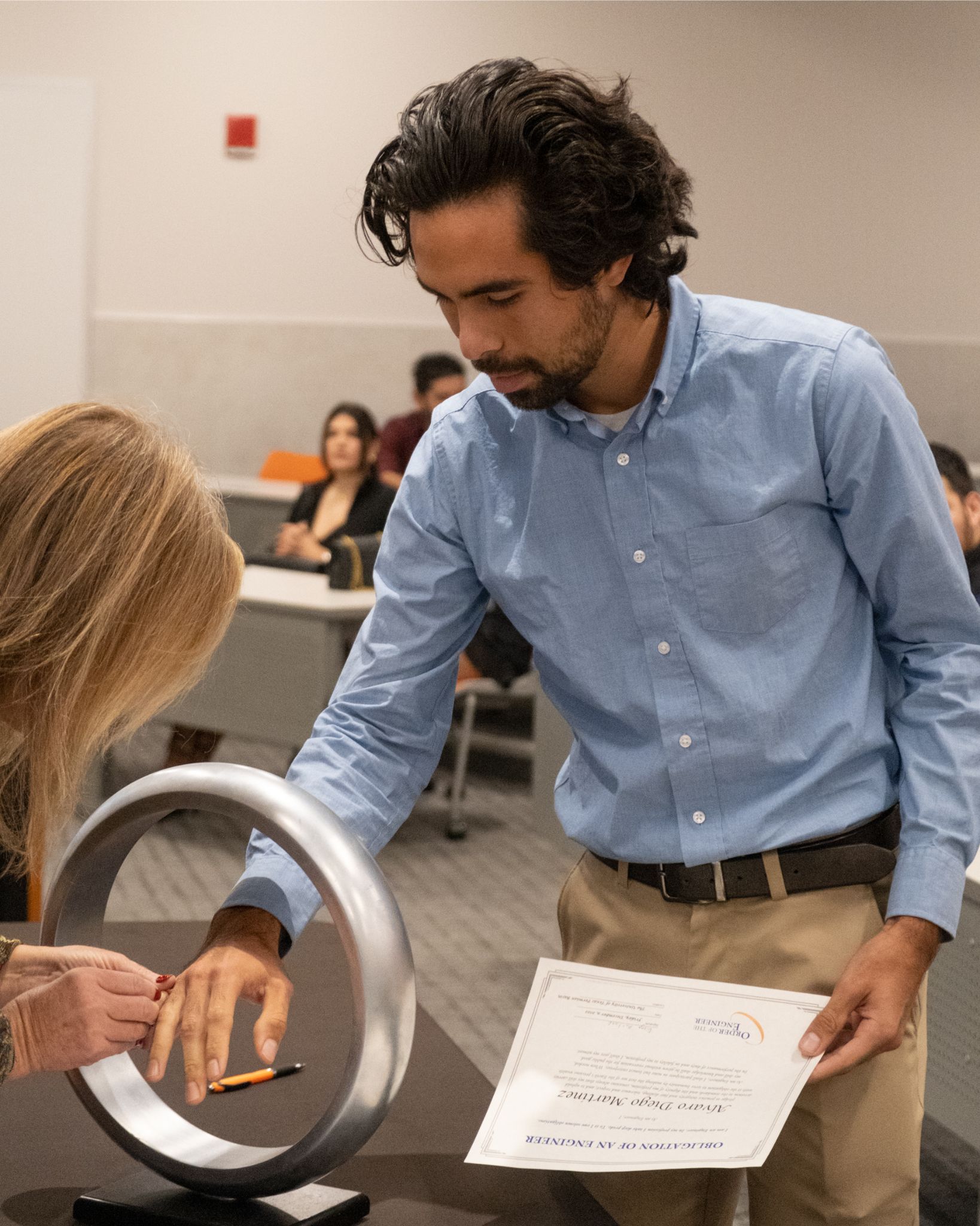 Estudiante varón recibiendo anillo en ceremonia